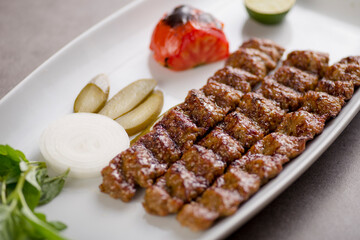 Meat seekh kebab served in dish isolated on grey background top view of arabic food