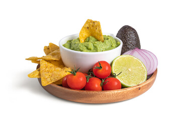 Guacamole bowl with nachos and ingredients, avocado, lime, onion, tomato