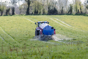 Fototapeta premium Farming blue lorry spraying the field
