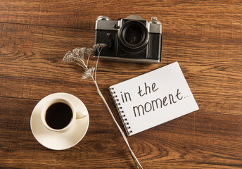 The inscription in the moment, a cup of coffee and an old camera