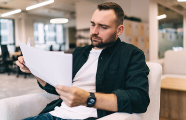 Serious businessman examining documents in office