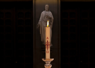 New Year. close-up of an candle in front of the icon of Jesus. 2023 and 2022.