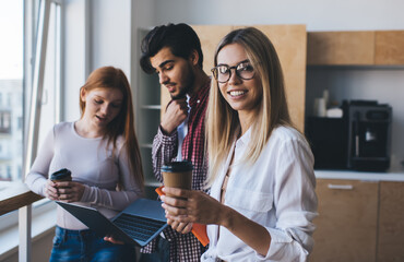Happy coworkers with coffee and laptop