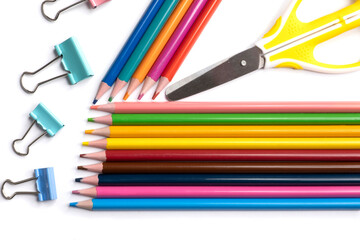 Colored pencils, paper clip and scissors for needlework isolated on a white background, a place for advertising.