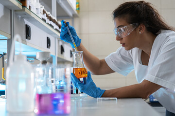 Female chemistry scientist doing experiments in lab.