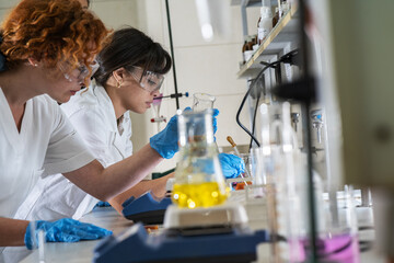 Two female chemistry scientists doing experiments in the lab.	