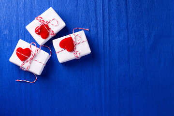 Boxes with presents with hearts  on  electric blue textured  paper background.  Place for text. Top view. Romantic postcard.