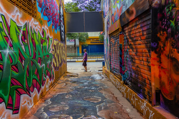 Um homem passando ao final do corredor do Beco da Codorna - um ponto turístico da cidade de Goiânia.