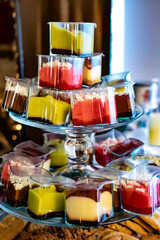 Colorful Variety of Mini Cheesecakes on a Clear Dessert Stand