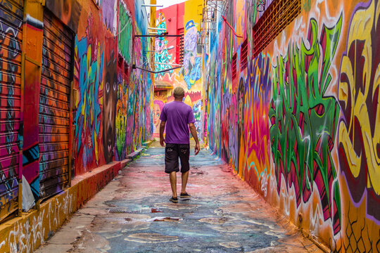 Um homem, de costas, caminhando pelo corredor do Beco da Codorna, um lugar pitoresco na cidade de Goi&acirc;nia. Ponto tur&iacute;stico.