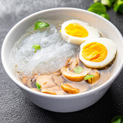 Fototapeta na wymiar asian soup rice noodles funchose, egg, mushrooms Pho Bo meal food snack on the table copy space food background rustic top view