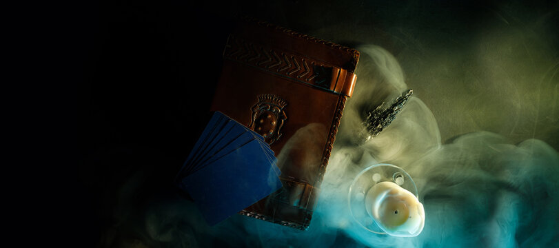 Mystical book of magic and tarot cards for divination on a dark table. Panoramic mockup for your logo. Horizontal banner with copy space for popular social media website cover image.