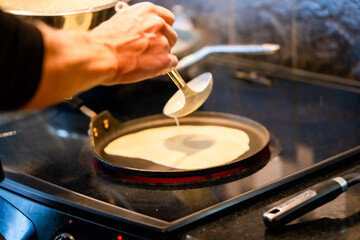 Fototapeta na wymiar Cooking crepes, flat pancakes in the home kitchen