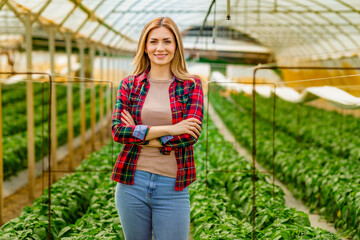 Portrait of a beautiful smiling agronomist woman in greenhouse.