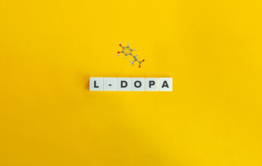 L-DOPA (levodopa) Molecule. Ball and stick Model and Word on Block Letter Tiles on Yellow Background. Minimal Aesthetics.