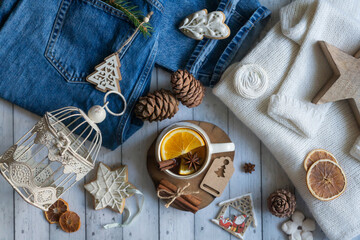 Hot tea with orange, sweets and decorations for the new year.