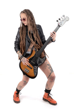 Woman with a bass guitar. Long dreadlocks. Tattoos all over the body