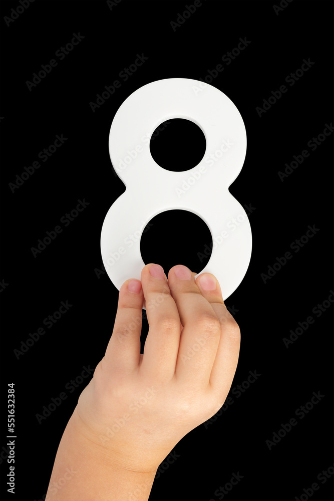 Poster number eight in hand isolated on black background. number 8 in a child's hand on a black background.