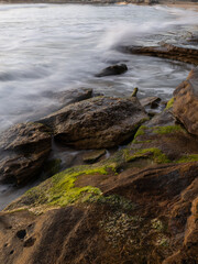 Rocky coastline with wave water flowing into it.