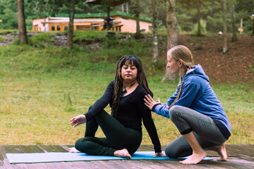 Yoga teacher supervising mature woman in concentration pose. Mental health.