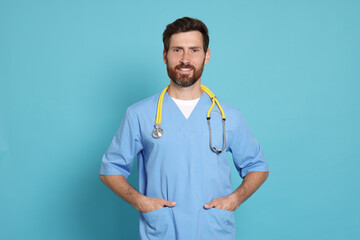 Happy doctor with stethoscope on light blue background