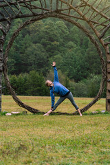 Caucasian woman practicing stretching exercise in a forest. Wellness.