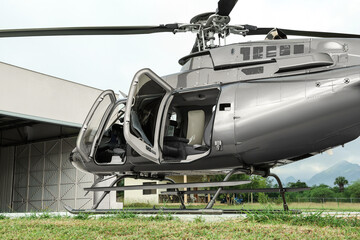 New helicopter with open cabin doors on helipad outdoors