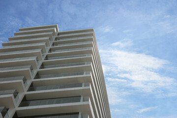 Fototapeta na wymiar Exterior of residential building with balconies against blue sky, low angle view. Space for text