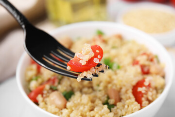 Fork with delicious quinoa salad, closeup view