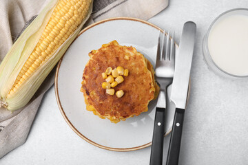 Tasty corn pancakes served on light grey table, flat lay