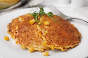 Tasty corn pancakes on white plate, closeup
