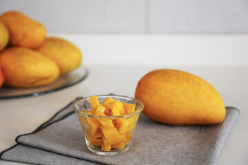 Delicious cut and whole mangoes on light table