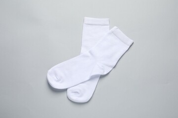 Pair of white socks on light grey background, flat lay