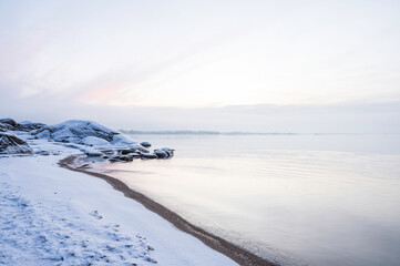 Winter sunset over a snowy beach and sea. 
Vexala, Finland.