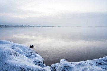 Winter sunset over a snowy beach and sea. 
Vexala, Finland.