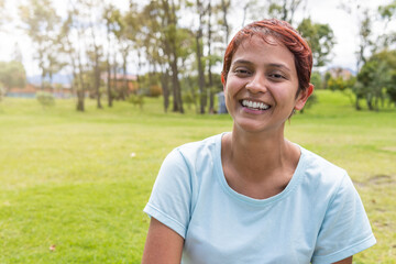 non-binary person smiling at camera happy in the park