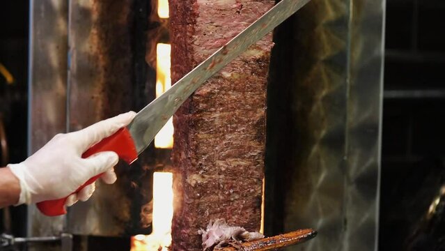 Meat doner cut close-up videos, cutting hanging doner. Turkish kebab iskender. Shawarma meat being cut before making
