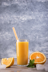 Fresh orange juice in glass on marble background.