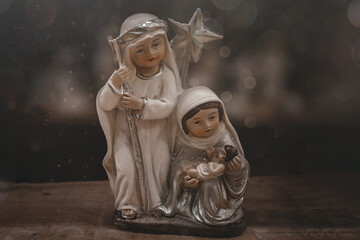 ceramic figurines of the mother of God joseph and baby jesus for the nativity scene on a dark brown...