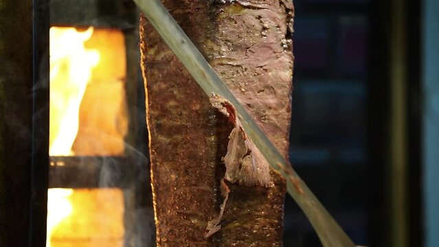 Meat doner cut close-up videos, cutting hanging doner. Turkish kebab iskender. Shawarma meat being cut before making