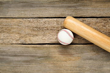 Baseball bat and ball on wooden table, top view with space for text. Sports equipment