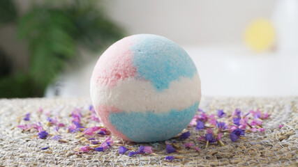 Beautiful bath bomb on wicker mat indoors, closeup