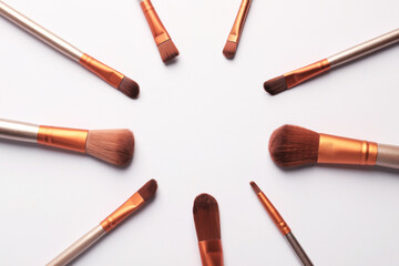 Frame of makeup brushes on white background, flat lay. Space for text