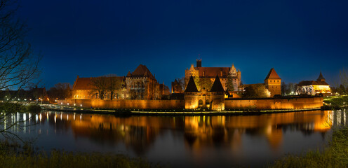 Illuminated Castle of the Teutonic Order in Malbork at night. December 2022 Poland.