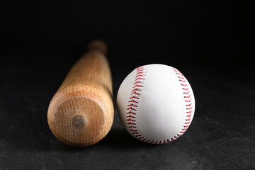 Baseball bat and ball on black background. Sports equipment