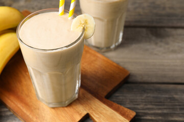 Glass with banana smoothie on wooden table, closeup. Space for text