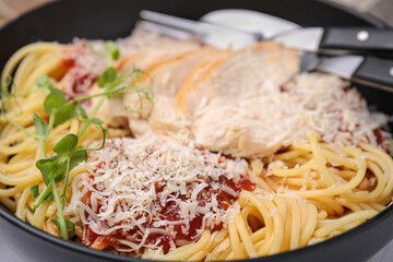 Delicious pasta with tomato sauce, chicken and parmesan cheese in bowl, closeup