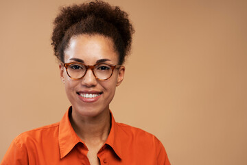 Smiling African American student wearing stylish eyeglasses isolated on background, education concept.  Closeup portrait of confident successful businesswoman looking at camera in studio 