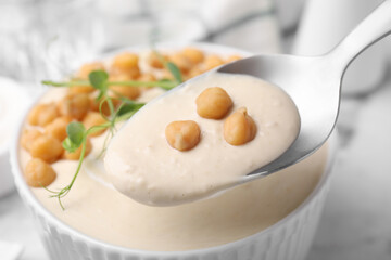 Eating tasty chickpea soup on table, closeup