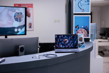 Coronavirus vaccination center showing illustrative images of covid 19 cell on laptop screen at administrative area. Medical clinic informing about coronavirus symptoms through representation on